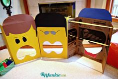 three cardboard boxes with faces on them sitting on the floor