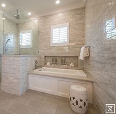 a large white bath tub sitting inside of a bathroom next to a walk in shower