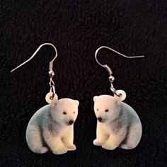 small white polar bear earrings on black background