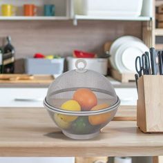 a mesh strainer filled with fruit on top of a kitchen counter