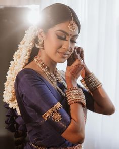 a woman in a blue sari holding her hands to her face