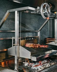 the meat is being cooked on the grill in the restaurant's large kitchen area