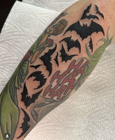 a man's arm with bats and letters on it, including the word happy halloween