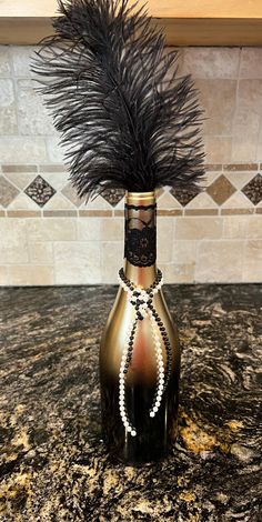 a vase with some feathers in it on a counter top next to a tile wall