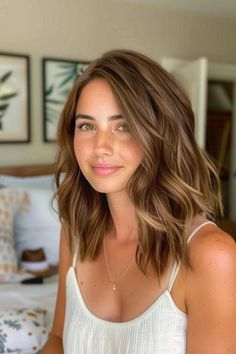 Woman with shoulder-length wavy hair smiling in a bedroom. Natural Brown Blonde Balayage, Hair Colour Caramel Brown, Full Caramel Highlights For Dark Hair, Short Caramel Hair Honey, Warm Caramel Honey Highlights, Dark Blonde Caramel Balayage, Brown Hair With Soft Blonde Highlights, Orange To Brown Hair, Soft Highlights Brown Hair