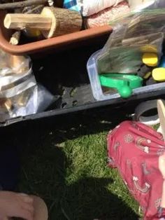 an open suitcase sitting on the ground next to other items in plastic bags and containers