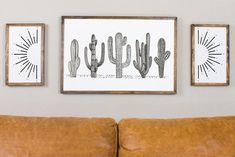 three framed pictures hang on the wall above a brown leather couch in a living room