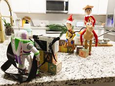 three toy figurines sitting on top of a kitchen counter next to each other