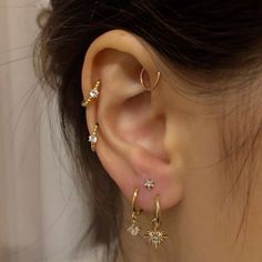 a woman wearing three different types of ear piercings