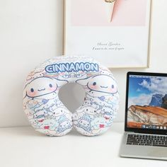 a laptop computer sitting on top of a desk next to an inflatable toy