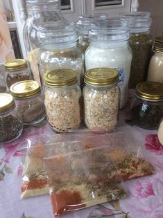 there are many jars and spices on the table with food in them to be used as condiments