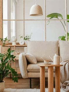 a living room filled with furniture and potted plants on top of a wooden table