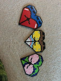 three pieces of bead art on the floor