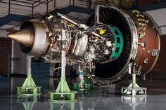 an airplane engine sitting on top of a cement floor next to two green and white cones