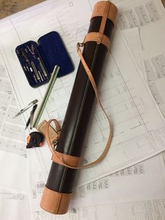 a leather case sitting on top of some construction plans