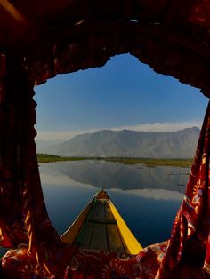 a view from the inside of a boat looking out over water and mountains in the distance