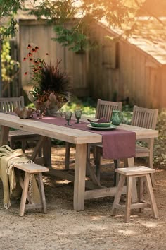 a wooden table and chairs in the middle of a yard