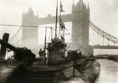 a black and white photo of a boat in front of the tower bridge with people standing on it