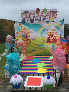 an assortment of candy and lollipops on display in front of a sign