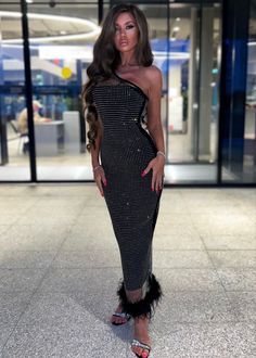 a woman in a black and white dress posing for the camera