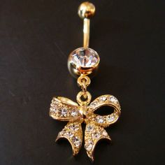 a gold bow belly ring with clear crystal stones