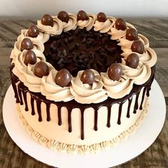 a chocolate cake with white frosting and chocolate candies on top