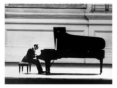 a man sitting at a piano in front of a wall