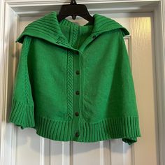 a green jacket hanging on a white door