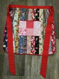 a patchwork purse with red ribbon on the side