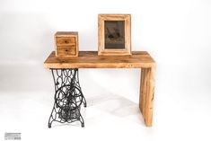 an old sewing machine sits next to a wooden table with two small frames on it