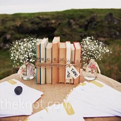 a table topped with books and vases filled with flowers