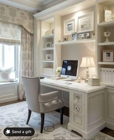 a desk with a computer on top of it in front of a window next to a chair