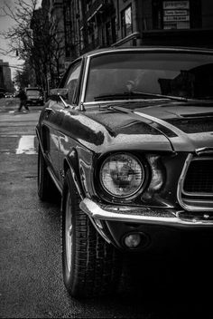 an old car is parked on the side of the road in front of some buildings