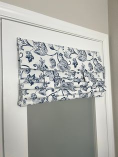 a blue and white window valance hanging on the side of a door