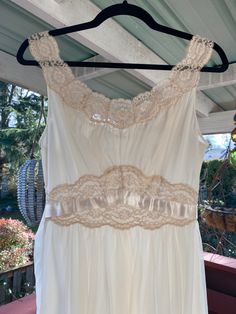 "1950's Vanity Fair Nightgown This cream colored nightgown is dreamy. She is a 1950's Vanity Fair size 32 Tricot Nylon two layer night gown trimmed in lace. She has two ribbon waist ties for decoration. Measurements provided are flat and have been doubled. Bust 32\" Waist 26\" Hips free Length 40\" ❤️ Condition: Excellent vintage condition. Flaw: waist tie ribbons have a few flaws, but they are not noticeable when worn. Please see pic. This item has been cleaned and is ready to wear. $68 include Cream Sleeveless Nightgown With Lace Trim, Sleeveless Cream Nightgown For Wedding, Sleeveless Lace Nightgown In Cream, Vintage Wedding Sleepwear With Lace Trim, Cream Lace Wedding Nightgown, Wedding Cream Lace Nightgown, Empire Waist Lace Trim Nightgown For Wedding Night, Elegant Empire Waist Lace Trim Nightgown For Wedding Night, Elegant Lace Trim Empire Waist Nightgown For Wedding Night