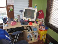 a computer monitor sitting on top of a wooden desk