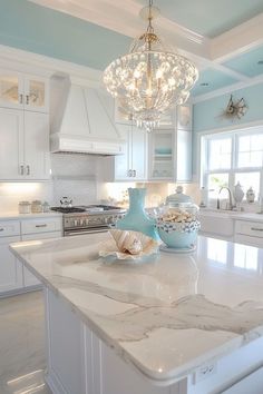 a white kitchen with blue walls and marble counter tops