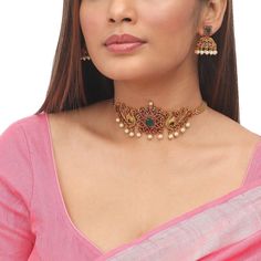 This necklace set will make you shine no matter the occasion. Studded with high-quality Kempu stones, we have crafted it to be lightweight and beautiful, all at the same time. Best of all: It is very versatile and will be a perfect match on any outfit.  Specifications: Weight 32 gm (necklace); 16 gm (earring); Length 12.5 cm (necklace); 3.5 cm (earring) Each piece is handcrafted and made to orders. All the raw material used in this product is of high quality and is handcrafted with love. 100% Satisfaction Guarantee:  1 Year Warranty, Long Lasting Plating, High-Quality Stones. Gifting:  This charming choker and earring set comes in a beautiful Tarinika gift box, making it an ideal gift for birthday, wedding anniversary or wedding gift.  Occasion: Perfect choice for any Indian occasion.  Car South Indian Temple, Indian Jewelry Set, Earring Indian, Indian Choker Necklace, Gold Jewels Design, Choker Necklace Designs, Gold Necklace Indian, Choker Designs, Temple Jewelry