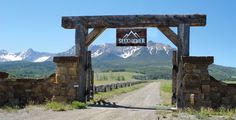 an old wooden gate with mountains in the background