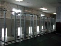 an empty room with lots of windows and bars on the sides, in front of a wall