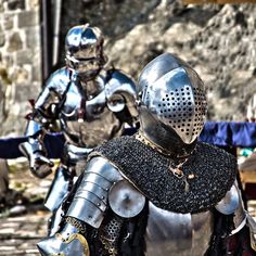 two knights dressed in armor walking down a street