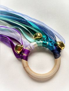 a wooden ring with multicolored ribbons and bells hanging from it's side