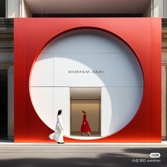 a woman walking past a red and white building with a large circular window on the side