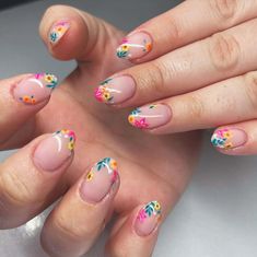 a woman's hands with pink and yellow flowers painted on their nail polishes