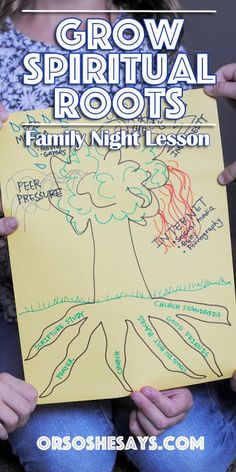 a child holding up a paper with the words grow and root roots written on it