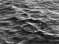 an abstract photo of water and land in black and white, taken from the air