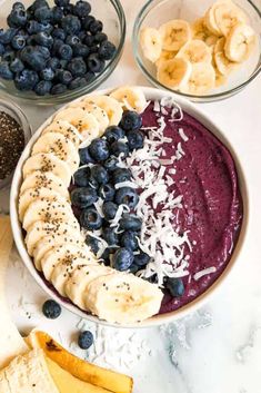 a bowl filled with blueberries, bananas and other foods