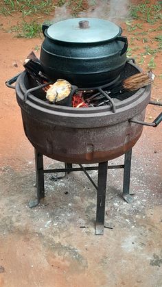 a big pot sitting on top of a bbq with some food cooking in it