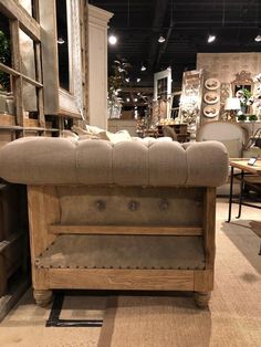 a bench made out of an old wooden frame and upholstered with leather, in a store