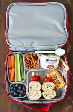 an open lunch box filled with food on top of a wooden table